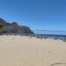 Rozległa złota plaża Playa de las Teresitas z palmami i ciemnymi górami Anaga w tle