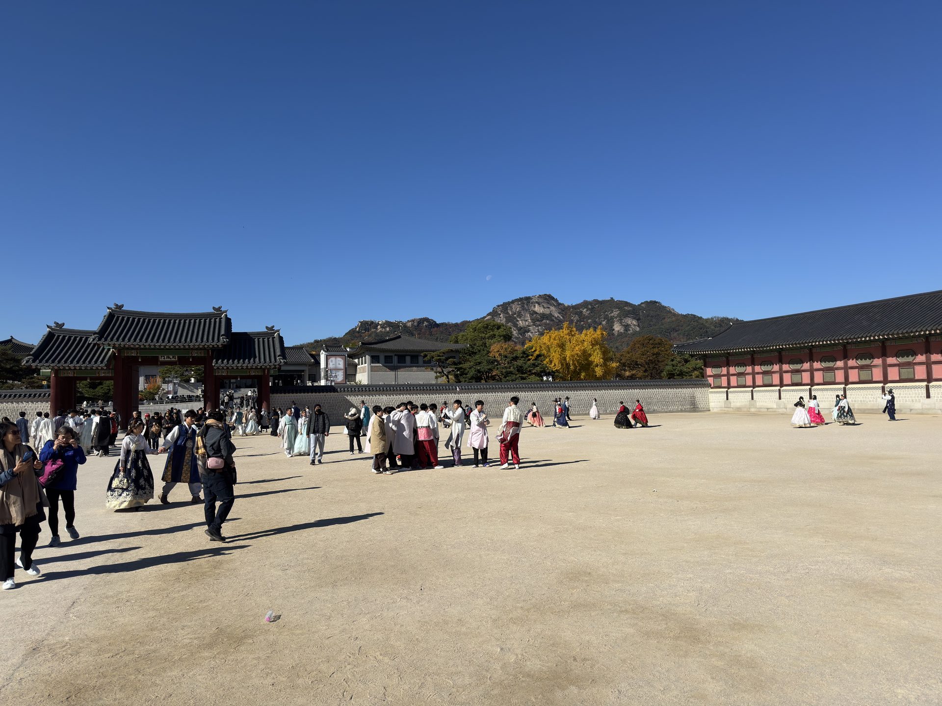 Turystki w kolorowych strojach hanbok na głównym dziedzińcu pałacu Gyeongbokgung