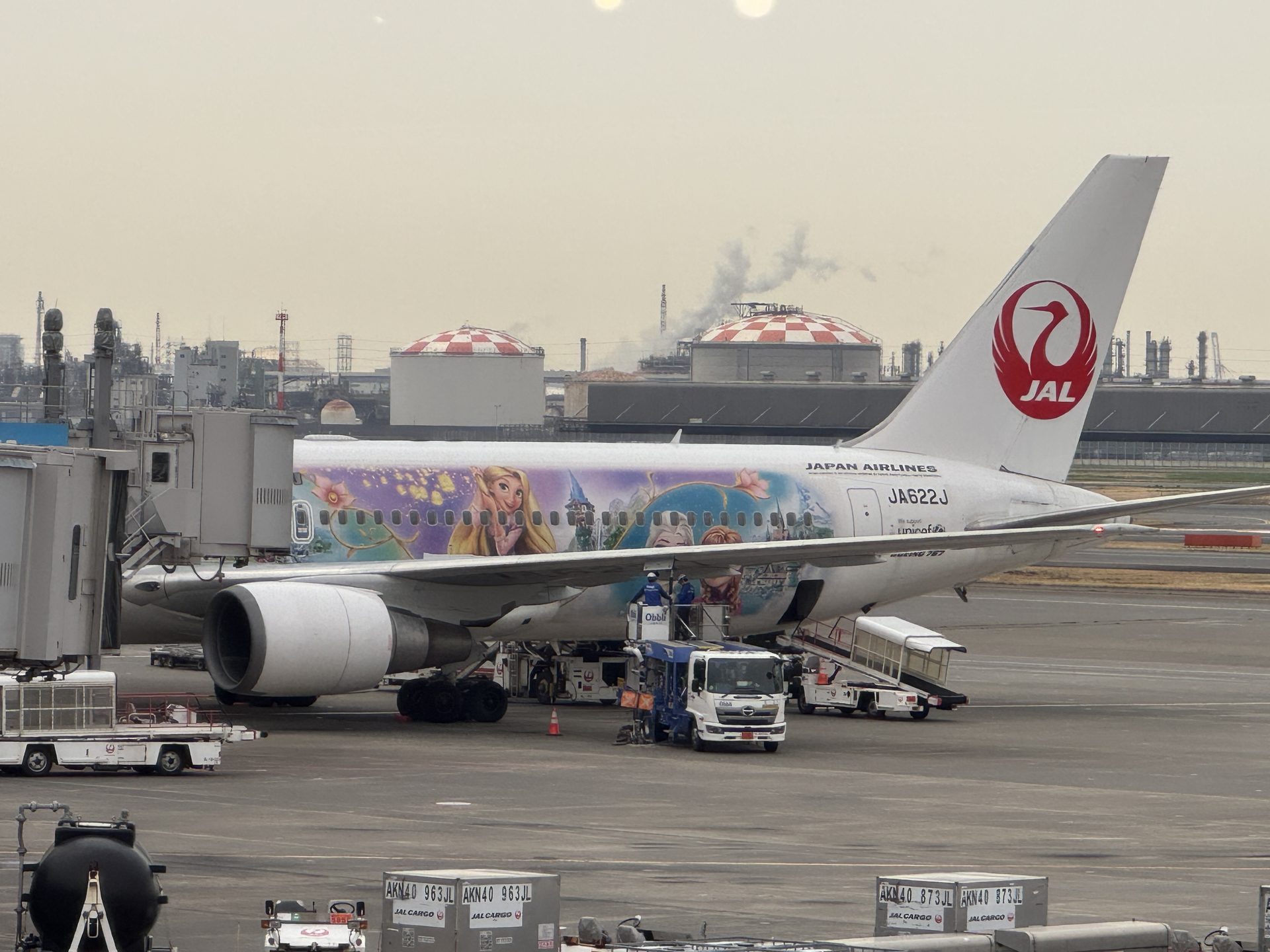 Boeing 767 Japan Airlines z malowaniem postaci Disneya przy bramce na lotnisku Haneda