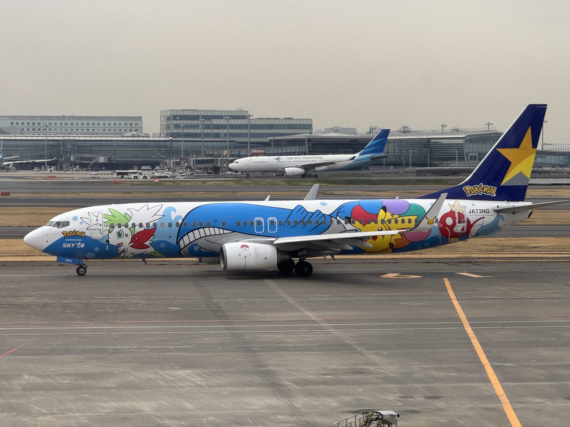 Boeing 737 Skymark Airlines z niebieskim malowaniem Pokémon Jet kołujący po płycie lotniska Haneda