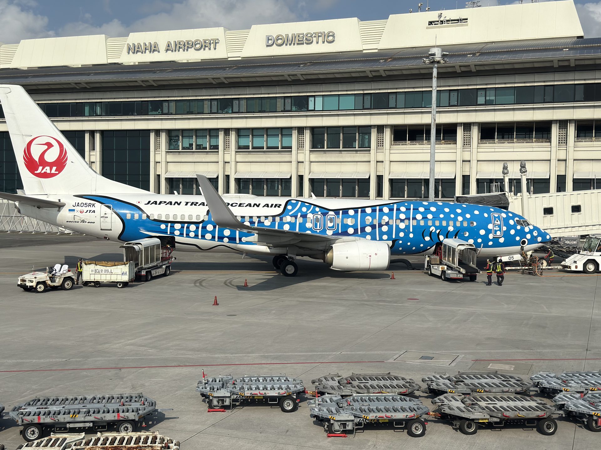 Boeing 737 Japan Transocean Air w charakterystycznym niebieskim malowaniu w grochy przy terminalu lotniska Naha na Okinawie