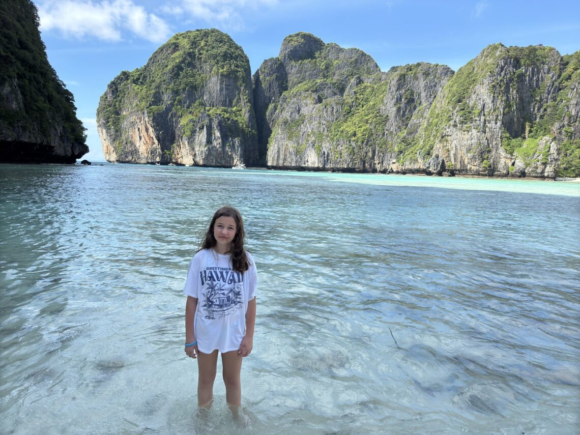 Marianna stojąca w turkusowej wodzie zatoki Maya Bay z imponującymi skałami karst w tle