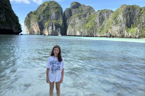 Marianna stojąca w turkusowej wodzie zatoki Maya Bay z imponującymi skałami karst w tle