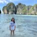 Marianna stojąca w turkusowej wodzie zatoki Maya Bay z imponującymi skałami karst w tle