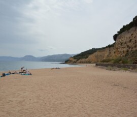 Plaża Cala Gonone Piaszczysta plaża Cala Gonone z klifami i spokojnym morzem