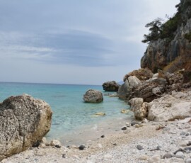 Dzika skalista plaża przy Cala Gonone Dzika skalista zatoczka z głazami i turkusową wodą przy Cala Gonone