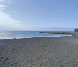 Puerto de la Cruz – czarna wulkaniczna plaża Rozległa czarna wulkaniczna plaża w Puerto de la Cruz z fortem przy morzu
