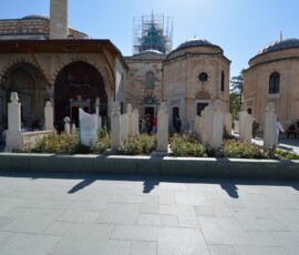 Przy mauzoleum Rumiego – tutaj spoczywa Jalāl ad-Dīn Muḥammad Rumi. Spokojne, pełne szacunku miejsce. Dziedziniec Mauzoleum Rumiego w Konyi z historycznymi nagrobkami i kopułami
