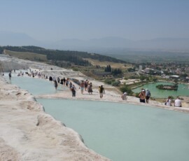 Tarasy Pamukkale – każdy patrzy pod nogi, bo biały kamień jest śliski! Białe wapienne tarasy Pamukkale z błękitną wodą termalną i turystami