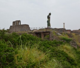 Pompeje – posąg na murach Brązowy posąg na murach starożytnych Pompejów