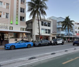 Ocean Drive – hotele Beacon i Colony z muscle car Hotele Beacon i Colony na Ocean Drive z niebieskim muscle carem na pierwszym planie