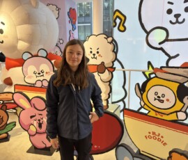 Marianna z postaciami BT21 w Shibuya Marianna stojąca przy wystawie figurek BT21 w Shibuya