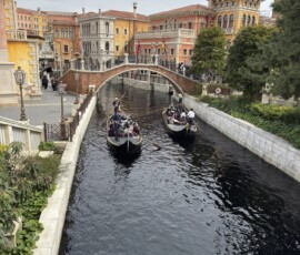 Gondole na kanale w Venice w Tokyo DisneySea Gondole Venice płynące pod kamiennym mostem w Mediterranean Harbor Tokyo DisneySea
