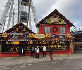 Hyde Park Winter Wonderland – stragan Polar Pots z London Eye Kolorowy stragan Polar Pots ozdobionym pluszakami z kołem widokowym London Eye w tle