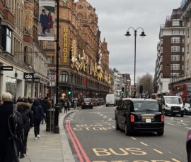 Knightsbridge – Harrods z czarnymi taksówkami i świątecznymi dekoracjami Ulica Knightsbridge z fasadą Harrods ozdobiną świątecznie, czarne taksówki na pierwszym planie