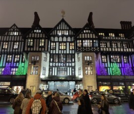 Liberty London – świąteczne iluminacje i choinki Fasada domu towarowego Liberty London nocą podświetlona fioletowo i zielono z choinkami