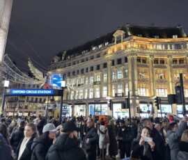 Oxford Circus – świąteczne iluminacje anioły nocą Tłum przy stacji Oxford Circus Station z unoszącymi się w powietrzu iluminacjami w kształcie aniołów