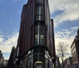 Oxford Street – nowoczesna wieżowiec Bosideng Smukły nowoczesny budynek z elewacją z brązowej stali z logo Bosideng przy Oxford Street