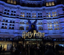 West End – Harry Potter and the Cursed Child nocą Podświetlona na niebiesko fasada teatru z napisem Harry Potter and the Cursed Child w West Endzie