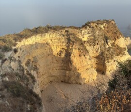 Klify Algarve – złote ściany skalne Złote klify Algarve widziane z góry z ukrytą plażą poniżej