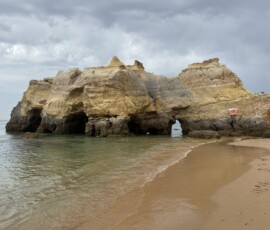 Skały Algarve przy plaży Masywna skała wapinna z grotami przy spokojnym morzu Algarve