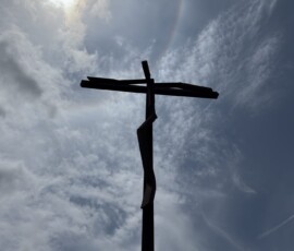 Krzyż w Fátimie na tle nieba Wysoki krzyż w Fátimie na tle pochmurnego nieba z halo słonecznym