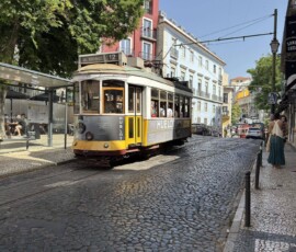 Tramwaj 28 na brukowanej ulicy Lizbony Żółty tramwaj 28 na brukowanej ulicy Alfamy w Lizbonie
