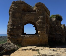 Ruiny z łukowym oknem w Agrigento Kamienne ruiny ze sklepionym łukiem na tle błękitnego nieba w Dolinie Świątyń