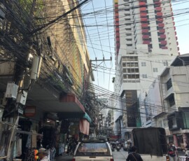 Bangkok – ulica z gąszczem kabli Wąska ulica w Bangkoku z chaotycznym splotem kabli elektrycznych nad głowami