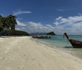 Phi Phi – Bamboo Island – plaża z longtailami Biała piaszczysta plaża Bamboo Island (Ko Phai) z zacumowanymi łódkami longtail