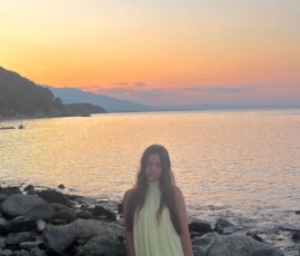 Marianna na plaży o zachodzie słońca Marianna stojąca na skalistej plaży podczas złotego zachodu słońca w Kokkino Nero