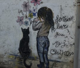 Mural dziewczynka z kotem w George Town Mural z dziewczynką trzymającą kwiaty i czarnym kotem w Penang