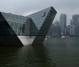 Louis Vuitton Island Maison nad Marina Bay Szklany pawilon Louis Vuitton na wodzie Marina Bay z panoramą wieżowców Singapuru