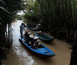Rejs łódką po delcie Mekongu Łódź sampan w palmowym kanale delty Mekongu w Wietnamie